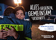 Zwei THW-Einsatzkräfte umarmen sich, dazu der Slogan "Alles gegeben. Gemeinsam geschafft." und der Hinweis auf die Seite "jetzt.thw.de"