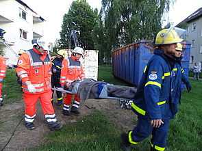 Einsatzkräfte transportieren verletzte Person auf Trage